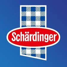 Schärdinger-Logo mit weiß-blauem Schachbrettmuster im Hintergrund und dem Markennamen in weißen Buchstaben auf einem roten Oval.